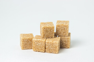 Cane sugar on a white background. Brown refined cane sugar.