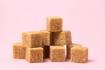 Cane sugar on a pink background. Brown refined cane sugar.