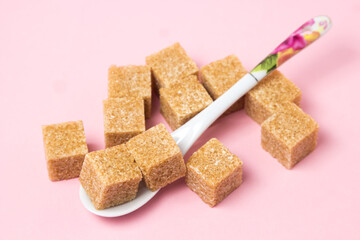 Cane sugar on a pink background. Brown refined cane sugar.