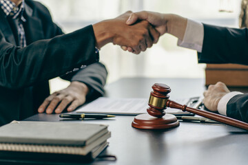 Businessmen shake hands to seal an agreement with a partner lawyer or lawyer who discusses the terms of the contract. The concept of a businessman's legal advisor.