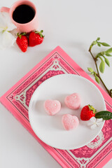 Branch composition with flowers, strawberries and candies. Food styling. Spring comfort food composition.