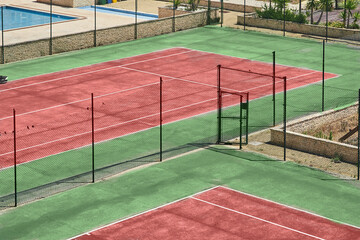 Tennis court stadium with red ground during the summer