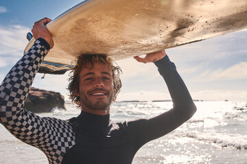 Surfer man athlete with wet hair holding surfboard at the head on summer beach - obrazy, fototapety, plakaty