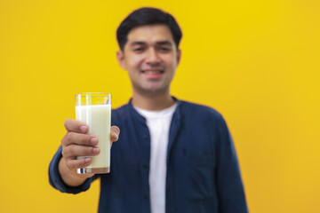 Young man in a good mood holding a glass of milk with love health concept. Increase calcium by drinking milk and Milk is an excellent source of vitamins and minerals.health concept