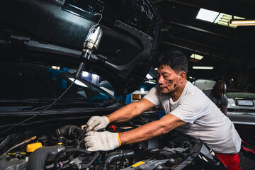 Fototapeta na wymiar Male mechanic wearing gloves checking the engine in the garage.