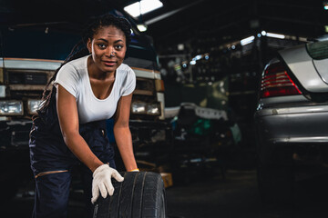 Female mechanic wearing gloves checking wheels and tires.