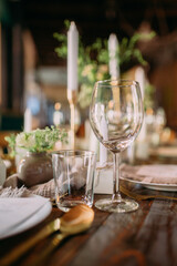 Festlich gedeckter Tisch auf einer Hochzeit mit Weingläsern und Kerzen in einer Scheune...
