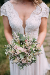 Brautstrauss mit Eukalyptus und Schleierkraut hell pastellfarben in der Hand einer Braut im...