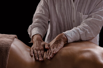 Fototapeta premium a girl makes a massage with oil close-up on a dark background