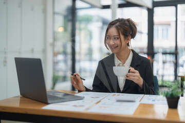 Portrait of asian business woman using laptop computer for financial analysis.