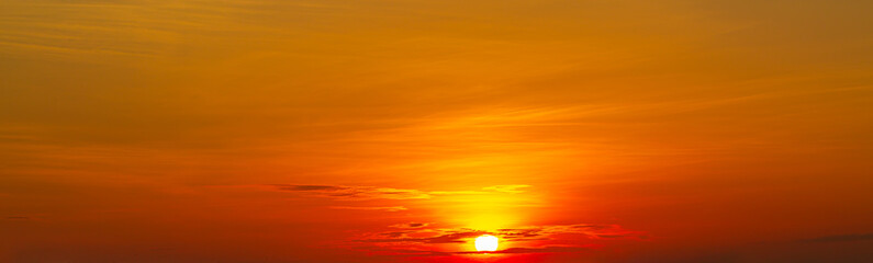 Panoramic views of strong sunrise with silver lining and orange sky clouds.