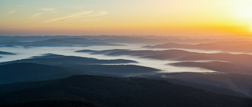 Morning fog in autumn mountains. Beautiful sunrise on background. Landscape photography panorama