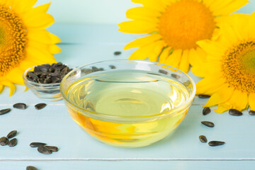 Sunflower oil, seeds and flower on wooden table