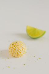 White chocolate candies and lemon slices on white background. Food Styling. Spring and Summer comfort food.