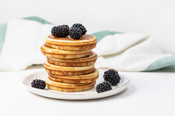 Pancakes on plate with blackberries. Healthy breakfast with fruits