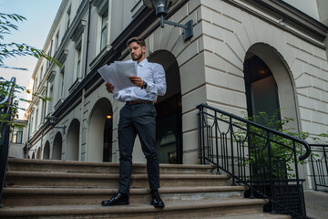 Shot of businessperson dressed in formal attire analyzing documents outdoors in fresh air.