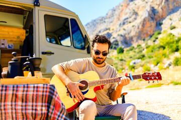 bearded man making fresh coffee near trailer house on wheels outdoors in summer day