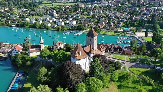 Aerial panoramic view of Spiez Church and Castle on the shore of Lake Thun in the Swiss canton of Bern at sunset, Spiez, Switzerland. Spiez Castle on lake Thun in the canton of Bern, Switzerland.