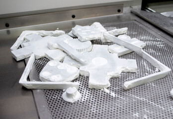 Detail objects printed on powder 3D printer and covered white polyamide powder close-up. Technology...