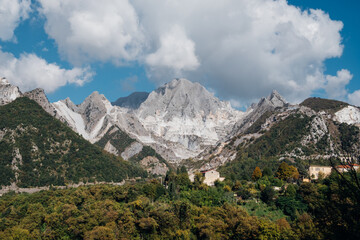 Marble quarry in Carrara, in Tuscany region, Italy. Famous location and place of interest. Mountain town view with white marble rock and blue sky.
