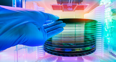 Gloved Hand Holding a Silicon Wafer in plastic holder box used in electronics for the fabrication of integrated circuits - obrazy, fototapety, plakaty