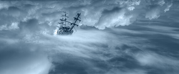 Sailing old ship flying over the clouds