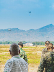 Back view of male parents look with worry and concern during parachute training from airplane for...