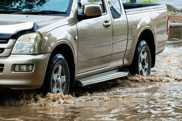 Pickup truck passing through flooded road. Driving car on flooded road during flood caused by...