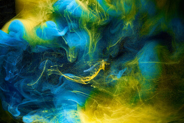 Liquid fluid art abstract background. Blue yellow dancing acrylic paints underwater, ocean space...