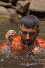 Young hindu indian coming out of water in vibhooti waterfalls