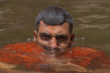 Brown skin indian man head out in water