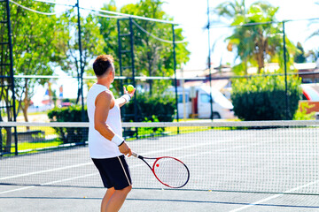 Senior caucasian man playing tennis on court holding tennis racket day light outdoors on fresh air