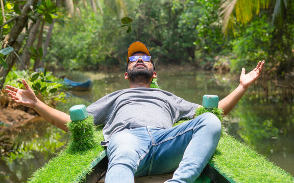 Young man lying on boat with face to sky in honnavar