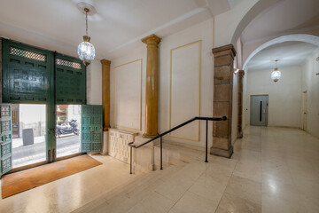 Portal of an old house with green wooden paneled door and marble stairs with black railing