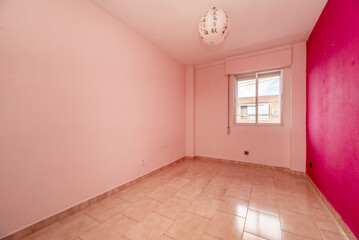 Empty living room in a residential house with stoneware floors and walls painted in various shades of pink