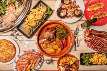 Delicious typical recipes of Galician gastronomy, knuckle with turnip tops, potatoes and sausages, scallops, betanzo omelette, grilled prawns, feira octopus, grilled monkfish