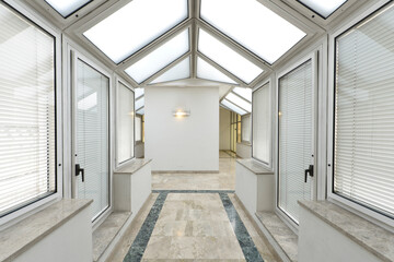 Passage with glass and aluminum ceilings and walls and marble floors with green edges