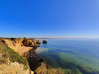 Fototapeta na wymiar Praia Dona Ana beach with turquoise sea water and cliffs, Portugal. Beautiful Dona Ana Beach (Praia Dona Ana) in Lagos, Algarve, Portugal. 