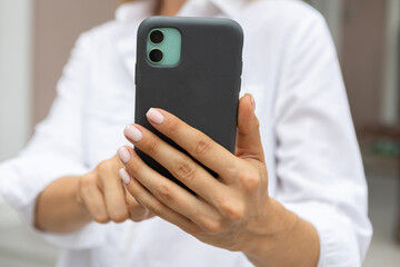 female hands hold a modern mobile phone on the street..education, modern app, shopping order, work online