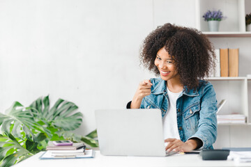 American teenage girl having a remote video call with friend on laptop, she is a student studying online at home, university student studying online, online web education concept.