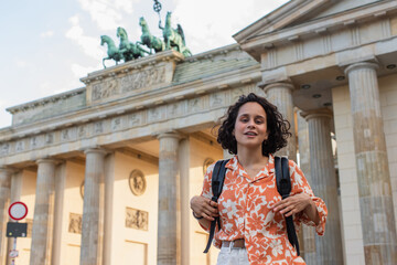 smiling tourist with backpack standing near brandenburg gate in berlin. © LIGHTFIELD STUDIOS