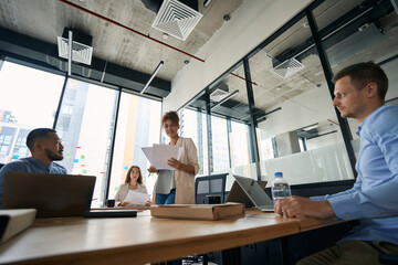 Young men and women are talking in conference in office
