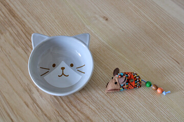 Bol, gamelle en forme de chat, accessoire et jeu pour chat sur fond bois, pour animal de compagnie.