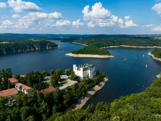 Fototapeta na wymiar Czechia, Orlik Castle and Vltava River Aerial View. Czech Republic. Beautiful Summer Green Landscape with Orlík Water Reservoir and Boats. View from Above. 