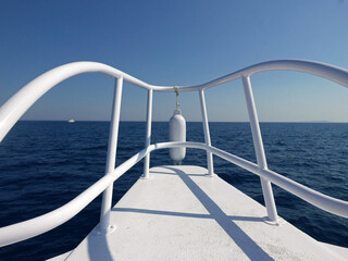 Fototapeta na wymiar la prua bianca di una imbarcazione nel mare azzurro in estate