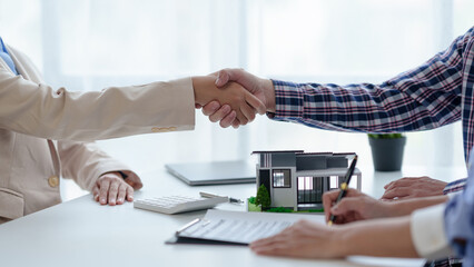 Real estate agent contracts to buy a house for a customer. shaking hands to congratulate.