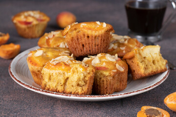 Homemade muffins with apricots and almonds on brown background, Close-up