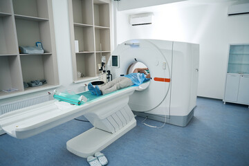 Patient lies in chamber of the tomograph in diagnostic center