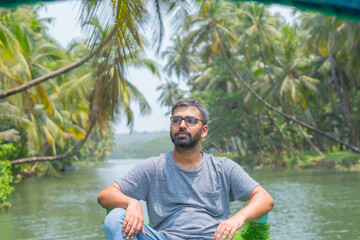 Naklejka na ściany i meble South indian man looking idle on boat in Honnavar river