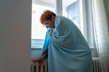 Senior woman feeling cold at home with home heating trouble